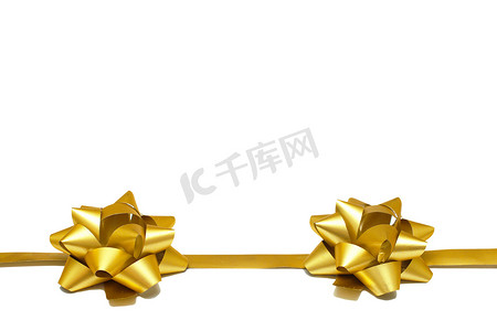 两个金色礼品蝴蝶结，白色背景上有丝带，有复制空间。