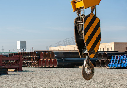 油田管道工地背景下建筑起重机吊钩的特写