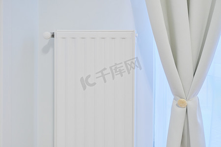 带温度恒温器的白色暖气散热器在公寓内部