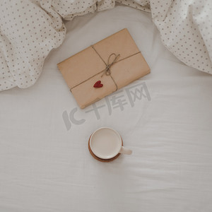 一杯加牛奶的咖啡和床上的礼品盒，上面有格子花呢，复制空间。