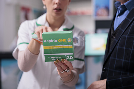 药房工作人员向药店顾客解释阿司匹林的副作用