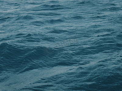 流动的水摄影照片_深蓝绿色的水面与波浪在无尽的深海中间。