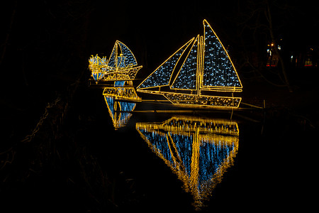小船摄影照片_波兰格但斯克奥利瓦公园的小船和小船假日灯饰。