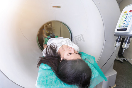 在一家现代医院接受计算机轴向断层扫描 CAT 扫描体检的漂亮年轻女性