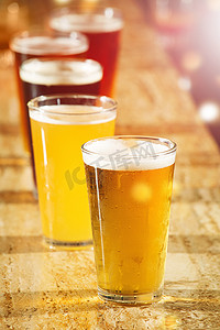 酒吧桌上的酒精、啤酒和眼镜，用于聚会、俱乐部和欢乐时光促销、销售和活动的商业背景。