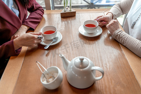 男人和女人手里拿着几杯红茶。