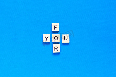 你写摄影照片_为你写在蓝色背景上的木制字母。
