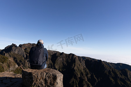 游客坐在山顶以雄伟的山脉为背景，马德拉，葡萄牙