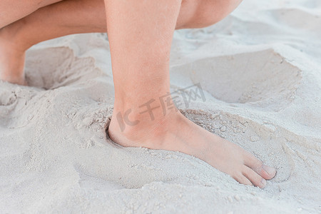 一个小女孩坐在她的腿上，站在温暖的白色沙滩背景上，特写