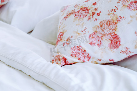 明亮的卧室内饰，床上有花卉图案枕头