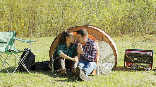 可爱的年轻夫妇在露营帐篷里度过了甜蜜的时光