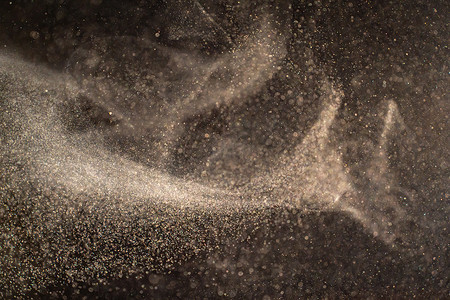 大气粒子摄影照片_漂浮在黑色背景光束上的有机尘埃颗粒。