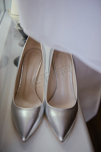新娘展示白色婚鞋。