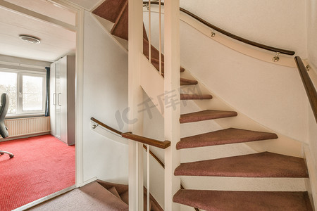 踏面摄影照片_家里铺着红地毯的螺旋楼梯