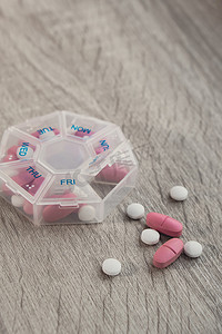 组织者每周拍摄药丸盒的特写镜头，里面装有每天用白色粉红色药物和胶囊服用的药片剂量。