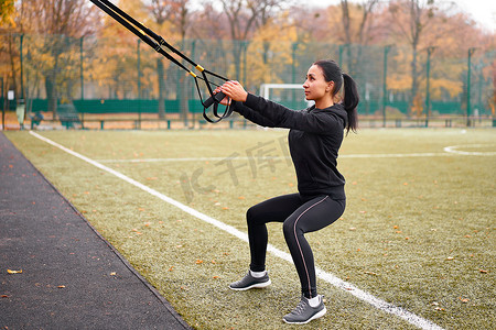 在运动场上使用 trx 进行女运动员训练。