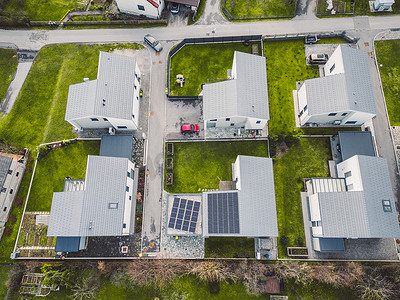 郊区新住宅的自上而下视图，其中一个屋顶上有太阳能电池板
