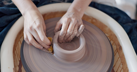 陶艺、艺术和手放在陶轮上，艺术家在创意课、车间或工作室中旋转粘土。