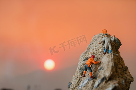 微型人物：攀登岩石的徒步旅行者。