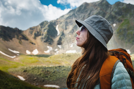 一个女人站在山上呼吸新鲜空气的侧视图画像。