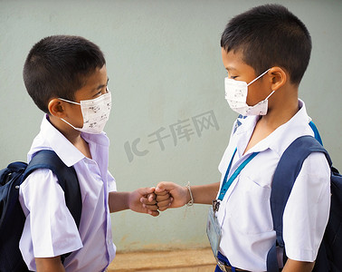 学生戴口罩抵御病毒和拳头碰撞