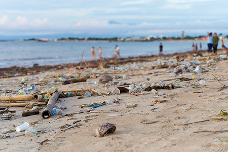 国潮水花摄影照片_潮水过后沙滩上堆积如山的废物和垃圾。