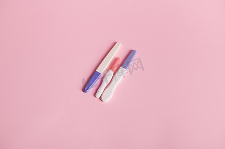 在孤立的粉红色背景上进行顶视图怀孕喷墨测试。