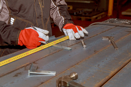 工人在角和卷尺的帮助下标记钻孔的位置。