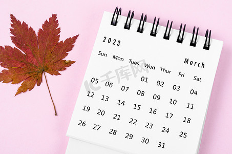 2023 年 3 月的 2023 年台历，粉红色背景为秋季枫叶。