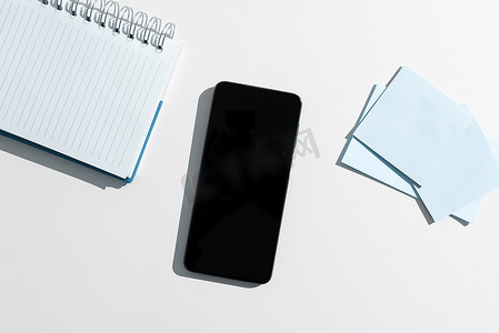 手机屏幕上有重要的想法，并在带有笔记本和记号笔的办公桌上贴着便条。