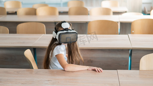 在教室里戴着虚拟现实眼镜的白人女学生。