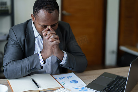 偏头痛摄影照片_精疲力尽的美国非洲商人在压力下处理许多文书工作文件、偏头痛发作、自由职业者、在家工作