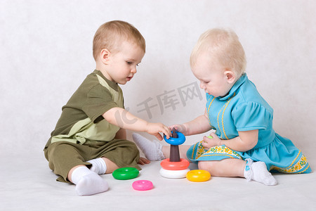 游戏设计师摄影照片_一个男孩和一个一岁半的女孩在上面玩金字塔