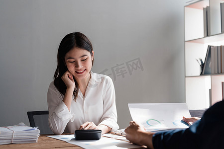 明年计划摄影照片_拿着笔和方格纸的女商人开会计划销售，以实现明年设定的目标……