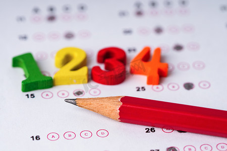 答题纸背景上的数学数字彩色和铅笔：教育学习数学学习教学概念。