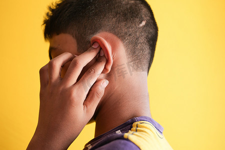 十几岁的男孩耳朵疼，摸着他疼的耳朵，