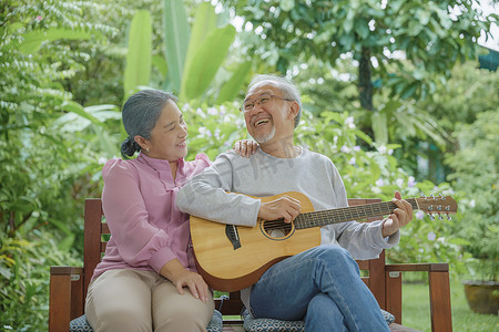 老夫妇弹吉他，而他的妻子正在一起唱歌