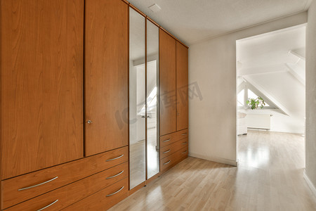 大型衣柜摄影照片_一间带木柜和一面大镜子的大卧室