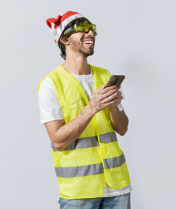 戴着圣诞帽的快乐工程师使用被隔绝的手机。