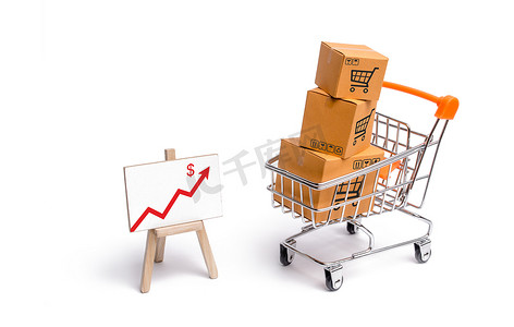 带盒子的超市购物车和带红色箭头的图表，商品：买卖商品和服务、互联网商务、在线购物、贸易和营业额的概念。