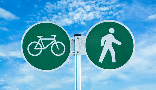 多云天空背景下的自行车和行人共用路线标志。
