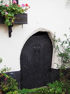 一扇古色古香的小木门，在白色的小屋墙壁上