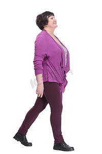 大踏步摄影照片_身穿紫色上衣的休闲老妇人大步向前。