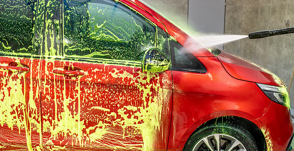 洗车请左转谢谢摄影照片_在车库里用绿色活性泡沫洗车