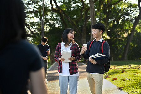 两名亚洲大学生在课后休息并在校园里转来转去。