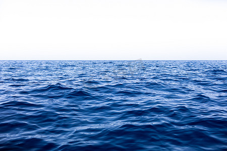 海面蓝色背景摄影照片_平静的海面海洋和蓝天背景。