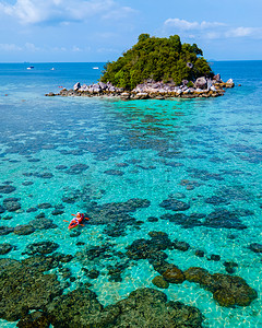 情侣海岛旅游摄影照片_在泰国丽贝岛前的一个小岛上划着皮划艇的情侣