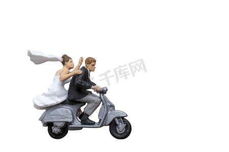 摩托车背景摄影照片_微型人物：骑摩托车的夫妇在白色背景中与剪裁路径隔离