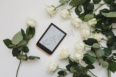 居家花卉摄影照片_花卉组成与平板电脑，白色背景上的新鲜白玫瑰。