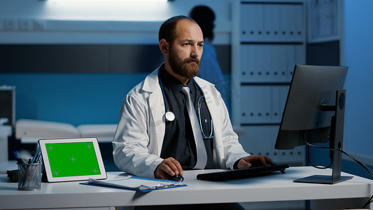 医院医生模板摄影照片_有站立在桌上的绿色屏幕色度键显示的片剂计算机